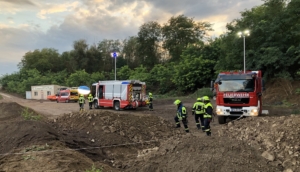 Foto zeigt die Feuerwehrfahrzeuge und Einsatzkräfte oberhalb der Abbaugrube.