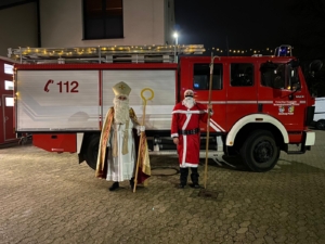 Das Foto zeigt •Nikolaus und Weihnachtsmann vor dem Tanklöschfahrzeug der Feuerwehr Plaidt.