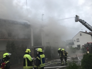 Foto zeigt die feuerwehr vor dem verrauchten Gebäude.