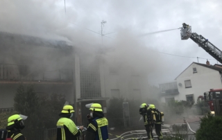 Foto zeigt die feuerwehr vor dem verrauchten Gebäude.